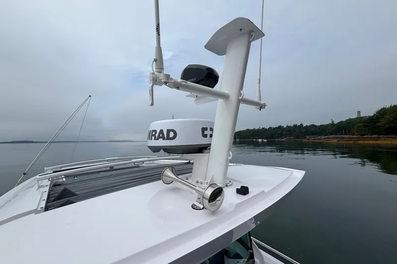 Slide: The Image of 2025 Axopar 29 XC Cross Cabin with radar equipment on calm water. - 45