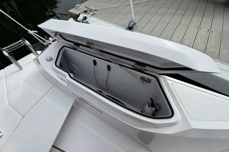 Slide: The Image of Open storage compartment on 2025 Axopar 29 XC Cross Cabin boat, dockside view. - 25