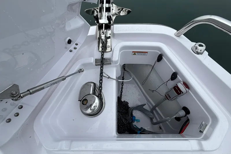 Slide: The Image of Anchor compartment of 2025 Axopar 29 XC Cross Cabin boat, featuring chain and winch. - 44