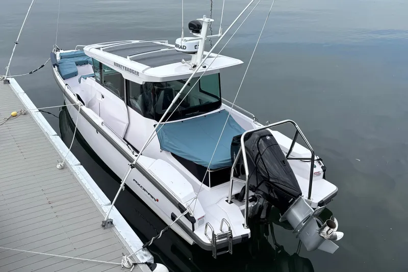 Slide: The Image of 2025 Axopar 29 XC Cross Cabin boat docked on calm water. - 5