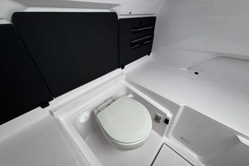 Slide: The Image of 2025 Axopar 29 XC Cross Cabin interior with compact marine toilet and sleek design. - 34