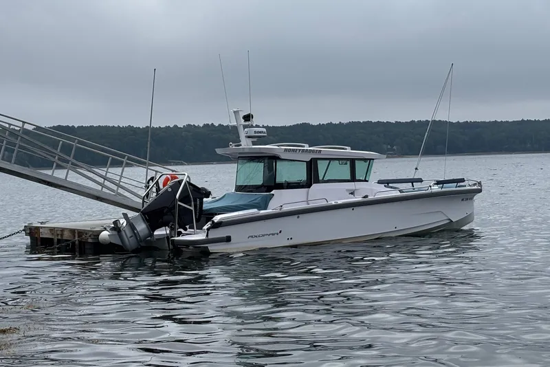 Slide: The Image of 2025 Axopar 29 XC Cross Cabin boat docked on a calm lake. - 8