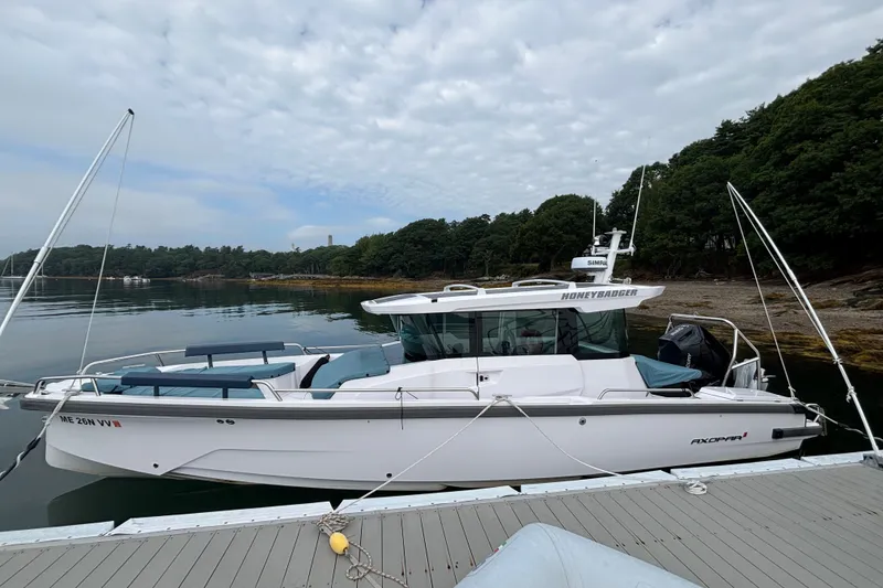 The Image of 2025 Axopar 29 XC Cross Cabin boat docked by a scenic shoreline. - 0