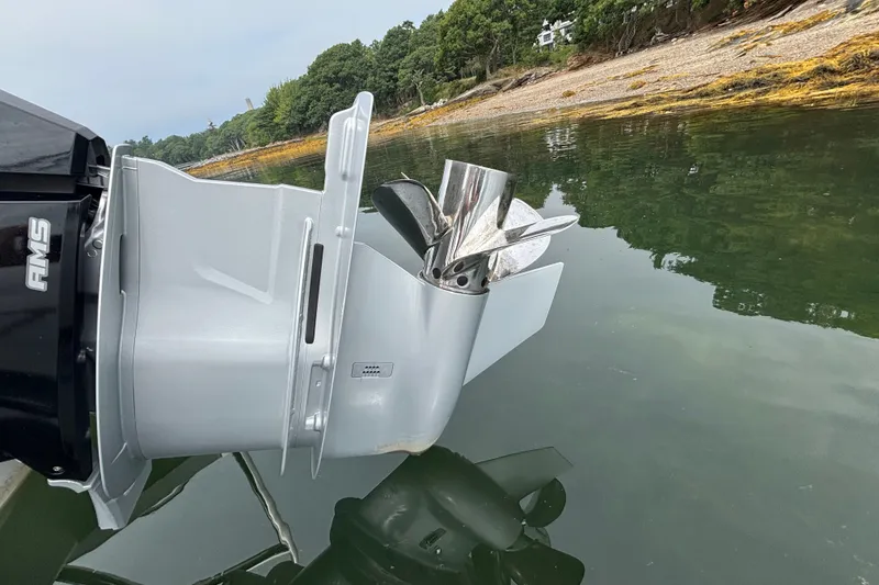 Slide: The Image of 2025 Axopar 29 XC Cross Cabin boat engine propeller in calm water near shoreline. - 24