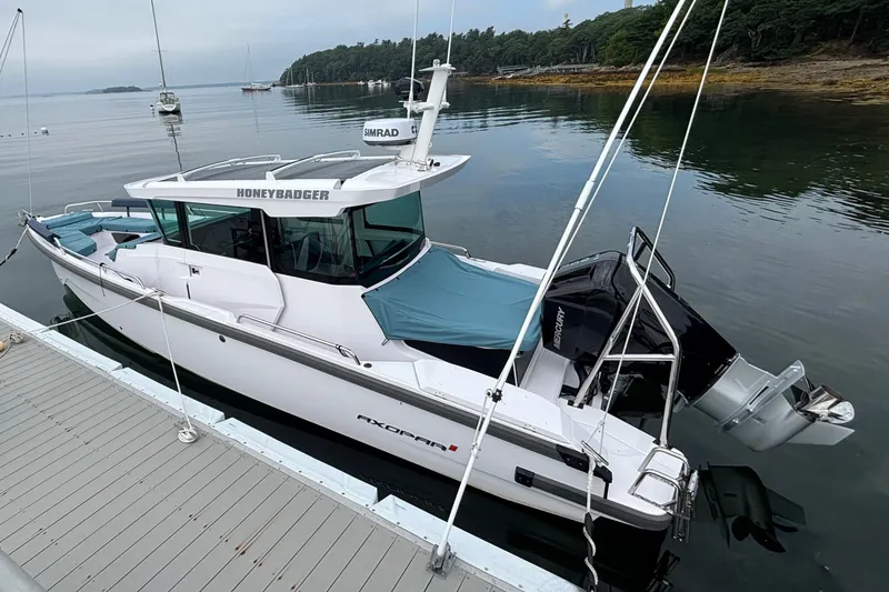 Slide: The Image of 2025 Axopar 29 XC Cross Cabin boat docked on calm water. - 7