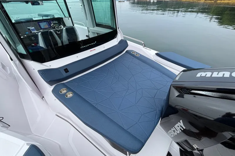 Slide: The Image of 2025 Axopar 29 XC Cross Cabin boat with blue seating and Mercury engine. - 41