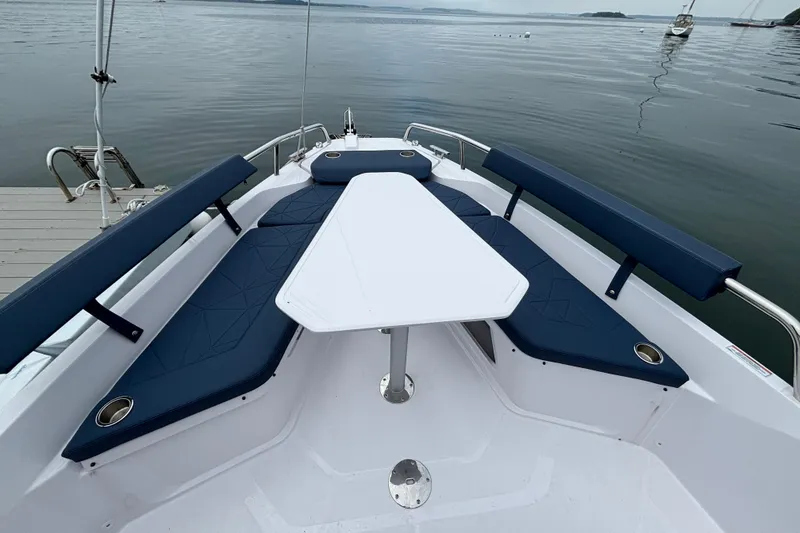 Slide: The Image of 2025 Axopar 29 XC Cross Cabin boat interior with blue seating and white table. - 39