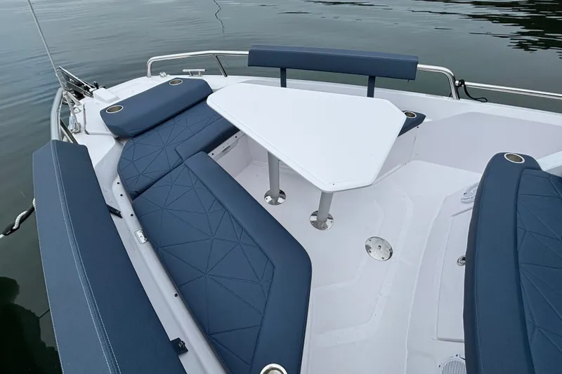 Slide: The Image of 2025 Axopar 29 XC Cross Cabin boat interior with blue seating and white table. - 10