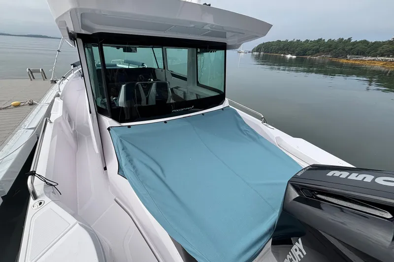 Slide: The Image of 2025 Axopar 29 XC Cross Cabin boat docked by calm waters. - 22