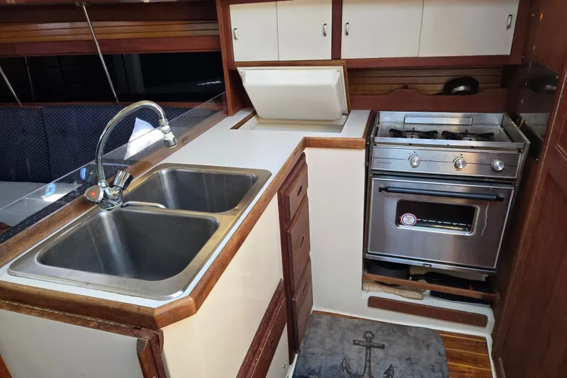 Slide: The Image of Compact kitchen in a 1989 Catalina 34 sailboat with sink, stove, and storage. - 18