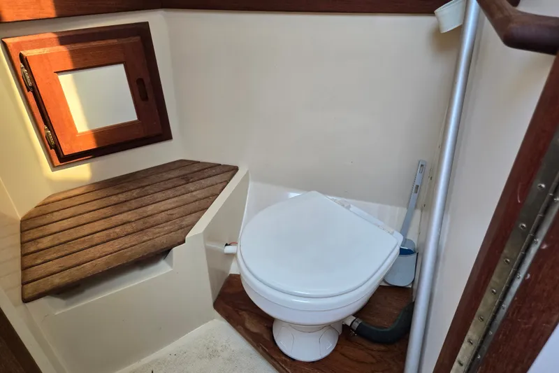 Slide: The Image of 1989 Catalina 34 yacht bathroom with wooden accents and compact toilet. - 27