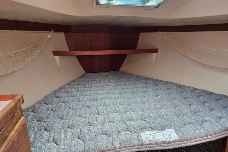 Slide: The Image of Cozy cabin interior of a 1989 Catalina 34 sailboat with a tufted mattress. - 22