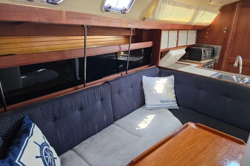 Slide: The Image of Interior of a 1989 Catalina 34 sailboat with cozy seating and kitchen area. - 14