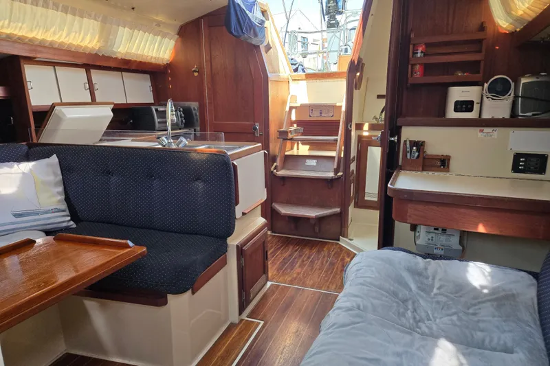 Slide: The Image of Interior of a 1989 Catalina 34 sailboat with cozy seating and wooden finishes. - 11
