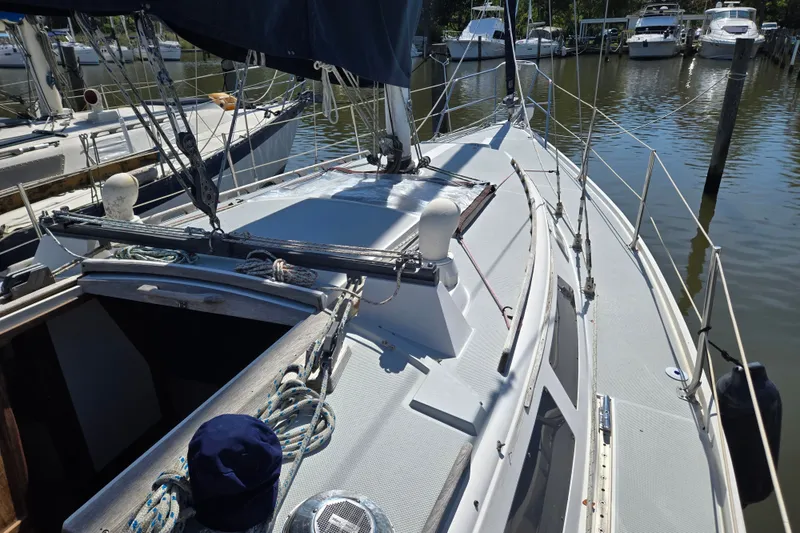 Slide: The Image of 1989 Catalina 34 sailboat docked at marina, showcasing deck and rigging details. - 5