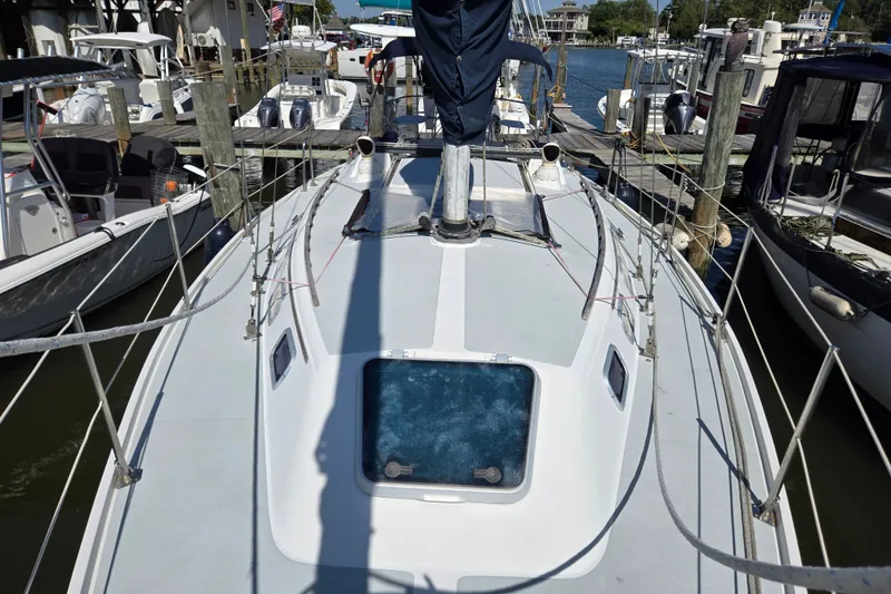 Slide: The Image of 1989 Catalina 34 sailboat docked at marina, showcasing deck and rigging. - 6