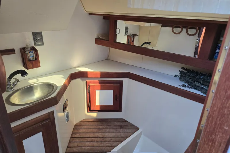 Slide: The Image of 1989 Catalina 34 yacht bathroom with sink, wooden accents, and mirror. - 24