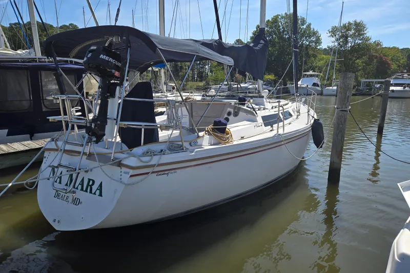 The Image of 1989 Catalina 34 sailboat docked in a marina, featuring a Mercury outboard motor. - 0