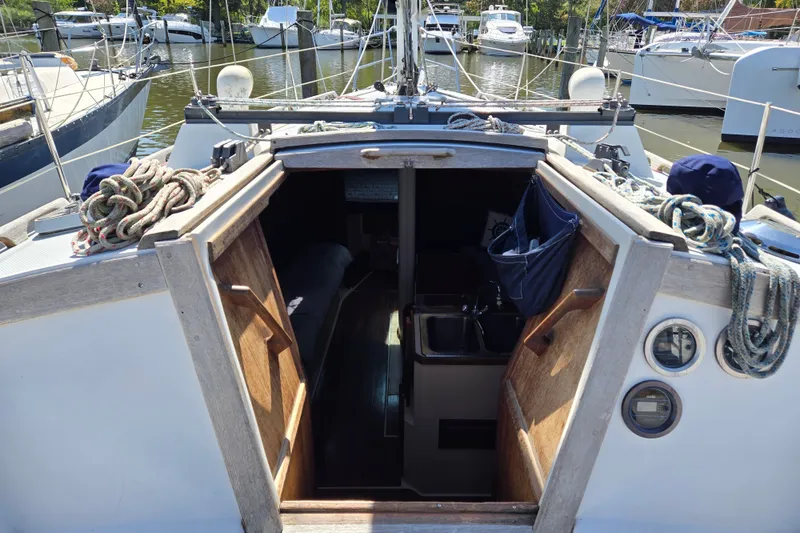 Slide: The Image of 1989 Catalina 34 sailboat interior view with ropes and marina background. - 10