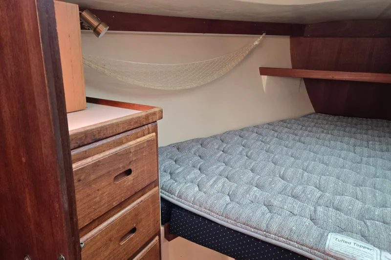 Slide: The Image of Cozy cabin interior of 1989 Catalina 34 sailboat with bed and wooden storage. - 23