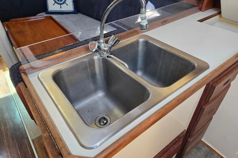 Slide: The Image of Double sink in 1989 Catalina 34 yacht kitchen with wooden accents and faucet. - 21