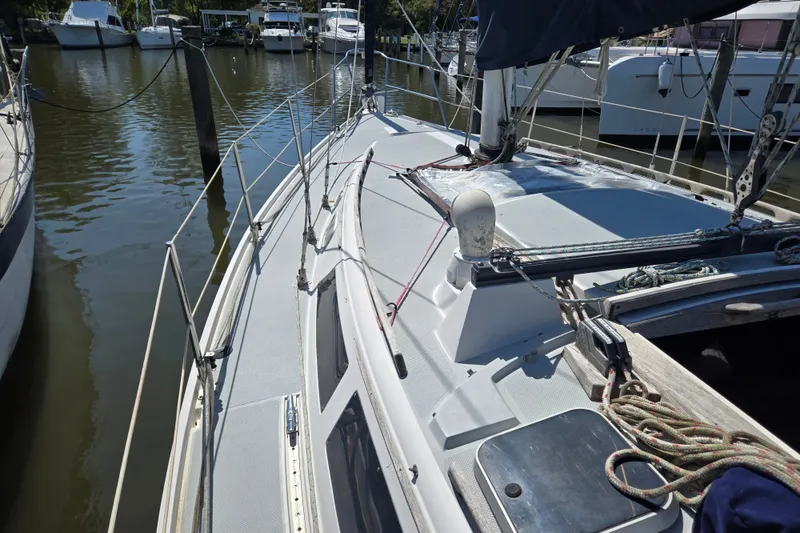 Slide: The Image of 1989 Catalina 34 sailboat docked at marina, showcasing deck and rigging details. - 4