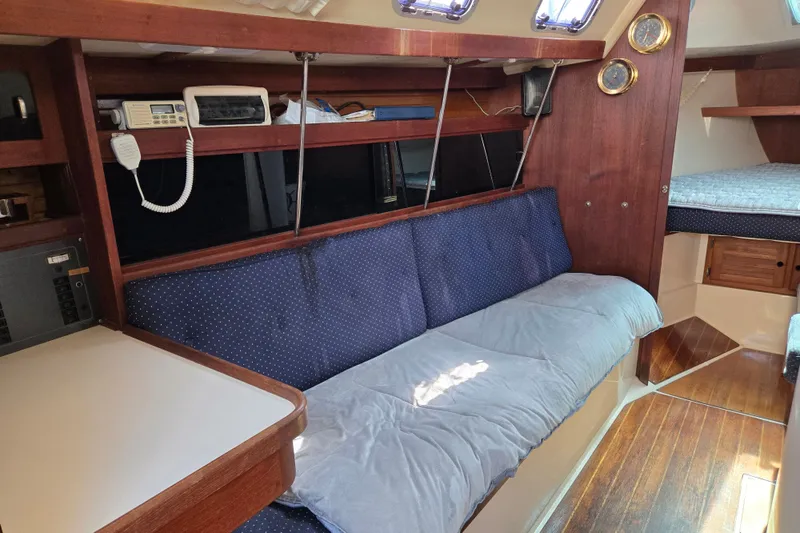 Slide: The Image of Interior of a 1989 Catalina 34 sailboat with cozy seating and wooden accents. - 13