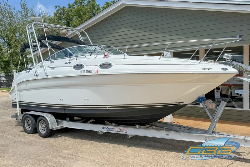 Slide: The Image of 2000 Sea Ray Sundancer 260 boat on trailer, parked outdoors near a building. - 18