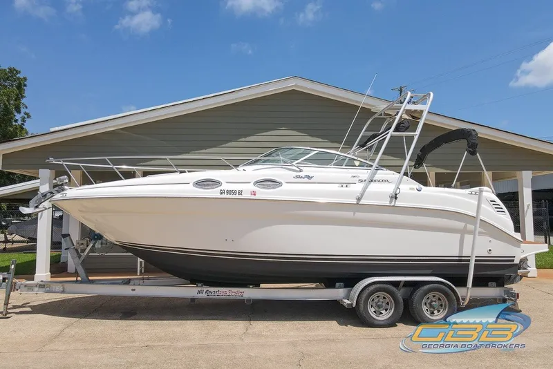 The Image of 2000 Sea Ray Sundancer 260 boat on trailer, displayed outdoors under clear sky. - 0