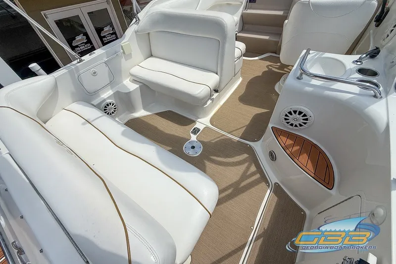 Slide: The Image of Interior of a 2000 Sea Ray Sundancer 260 boat with white seating and tan flooring. - 33