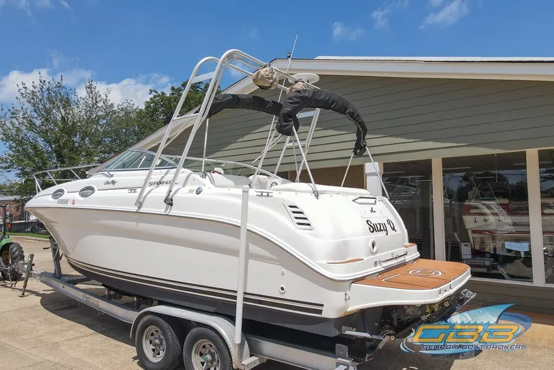 Slide: The Image of 2000 Sea Ray Sundancer 260 boat on trailer, displayed outdoors under clear blue sky. - 14