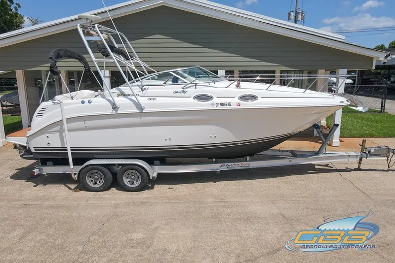 Slide: The Image of 2000 Sea Ray Sundancer 260 boat on trailer, parked outdoors, side view. - 26