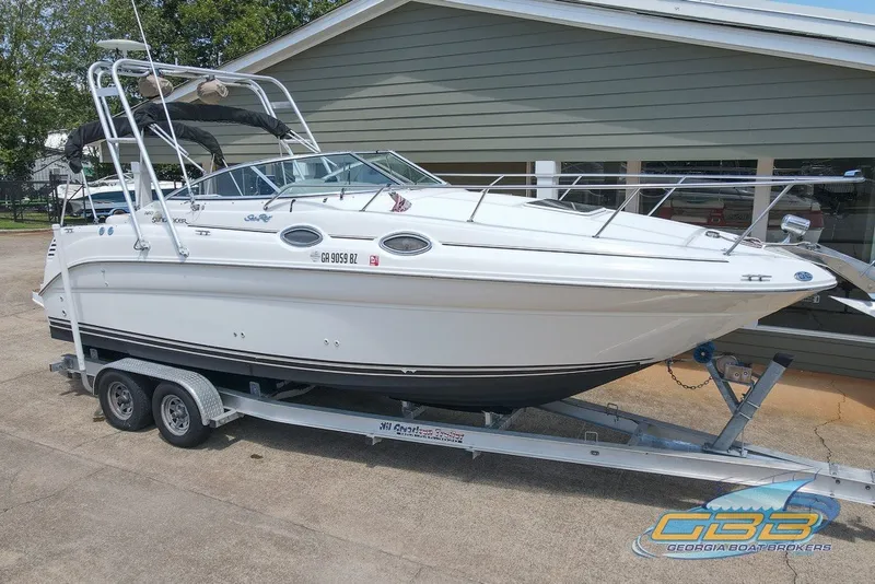 Slide: The Image of 2000 Sea Ray Sundancer 260 boat on trailer, parked outside a building. - 3
