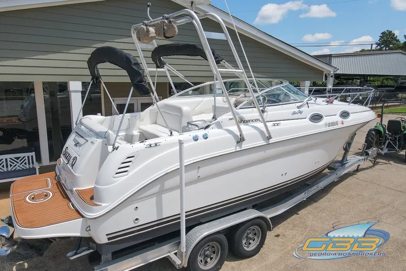Slide: The Image of 2000 Sea Ray Sundancer 260 boat on trailer, parked outdoors, with visible branding. - 28
