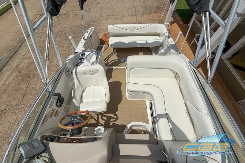 Slide: The Image of 2000 Sea Ray Sundancer 260 boat interior with white seating and steering wheel. - 23