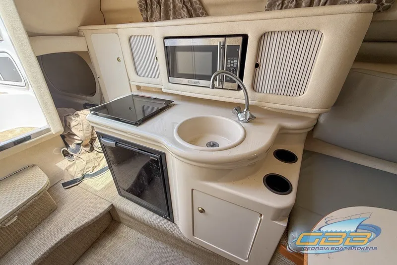 Slide: The Image of Compact kitchen area in a 2000 Sea Ray Sundancer 260 boat with sink and microwave. - 6