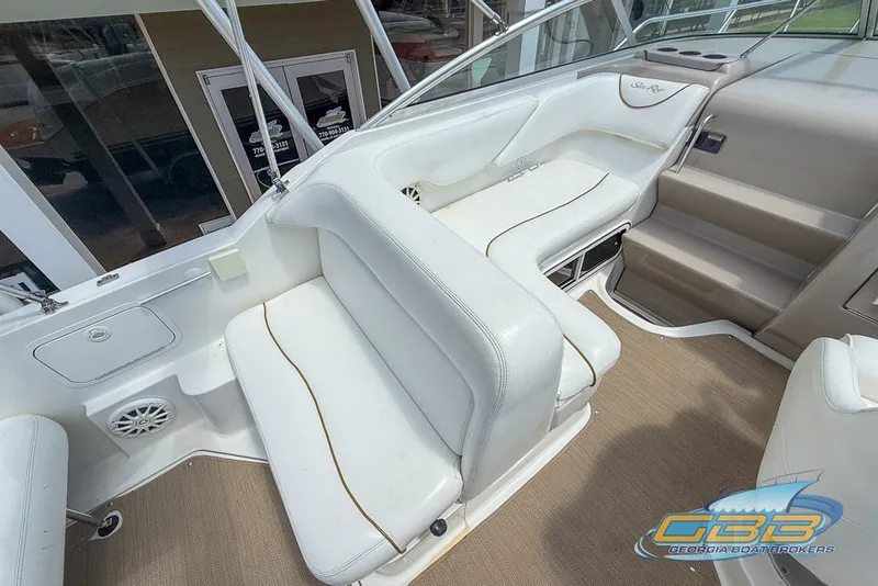Slide: The Image of Interior of 2000 Sea Ray Sundancer 260 boat with white seating and beige flooring. - 22
