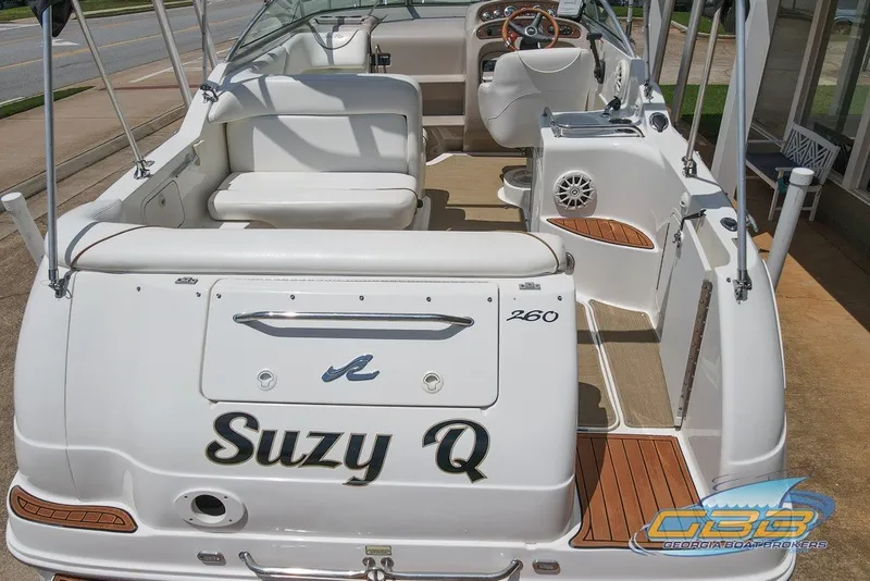 Slide: The Image of 2000 Sea Ray Sundancer 260 boat, rear view, named "Suzy Q," with white seating and wood accents. - 12