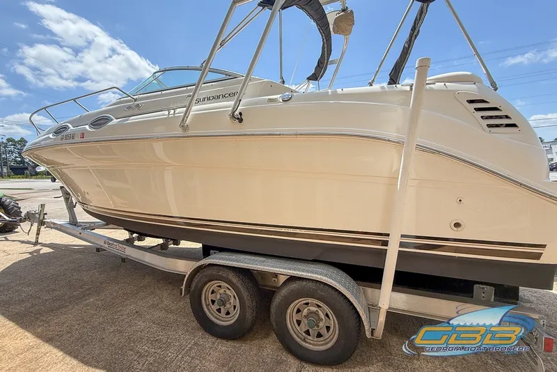Slide: The Image of 2000 Sea Ray Sundancer 260 boat on trailer under clear blue sky. - 11