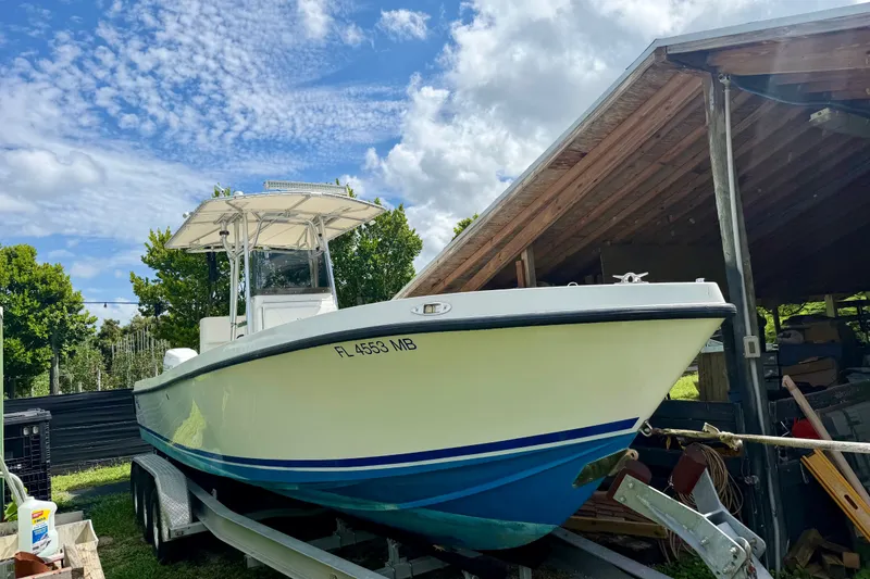 Slide: The Image of 2001 SeaVee 290B boat on trailer under shelter, clear sky background. - 17
