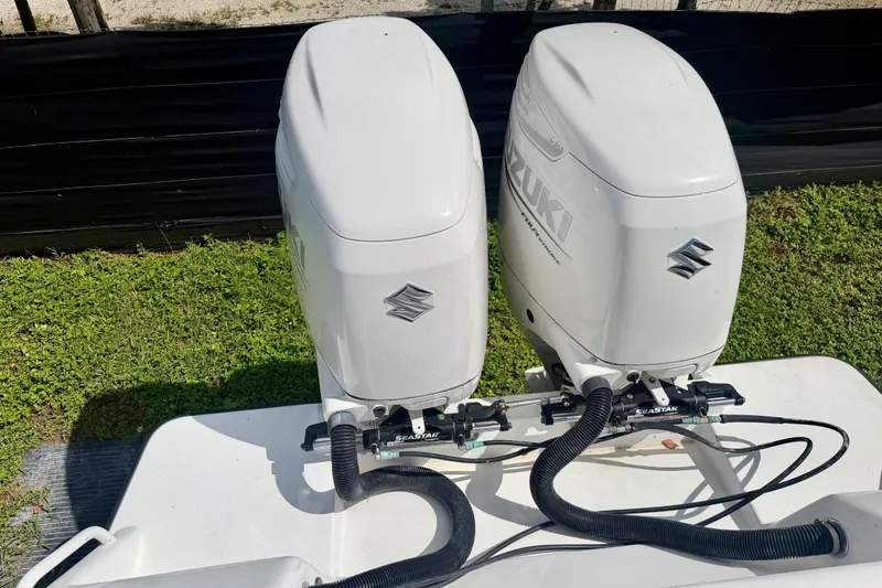 Slide: The Image of Twin Suzuki outboard motors on a 2001 SeaVee 290B boat, parked on grass. - 11