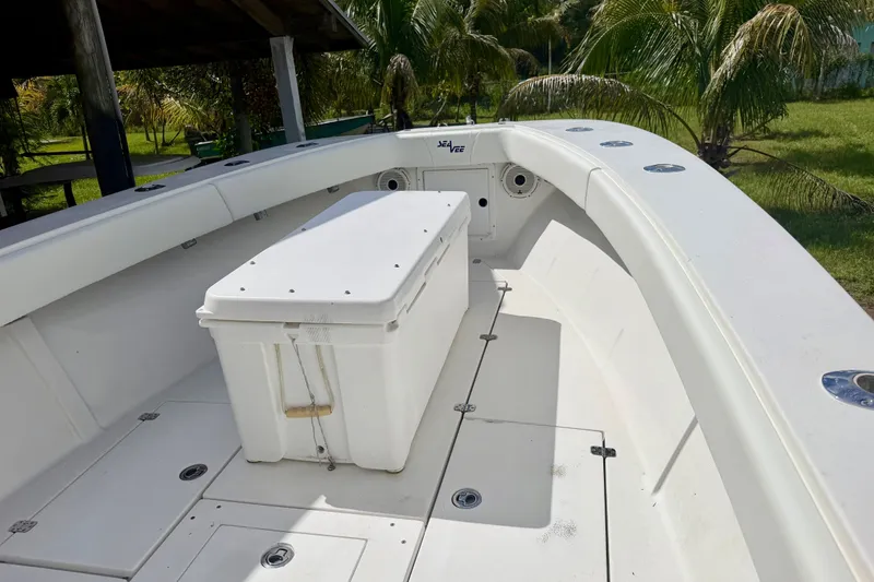 Slide: The Image of 2001 SeaVee 290B boat deck with storage box, surrounded by lush greenery. - 13