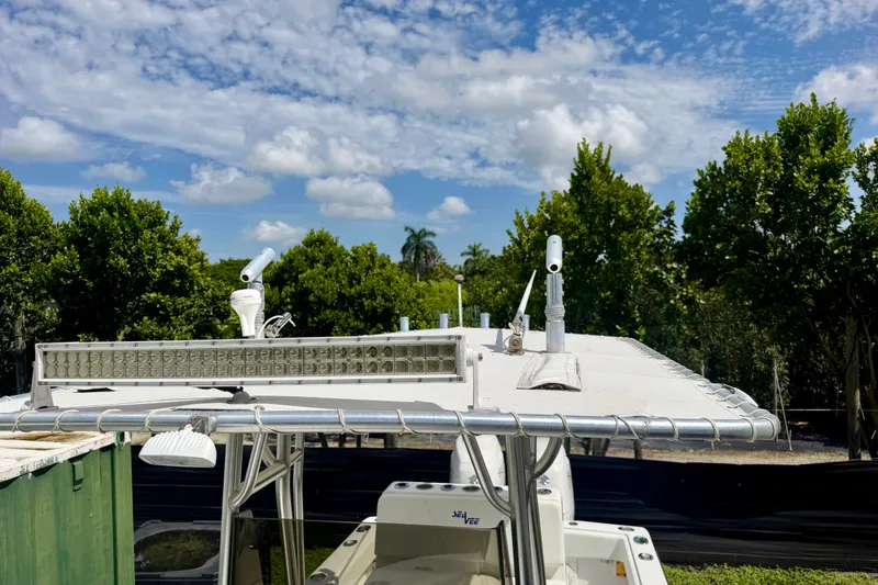 Slide: The Image of 2001 SeaVee 290B boat with canopy and equipment, set against a lush, green backdrop. - 4