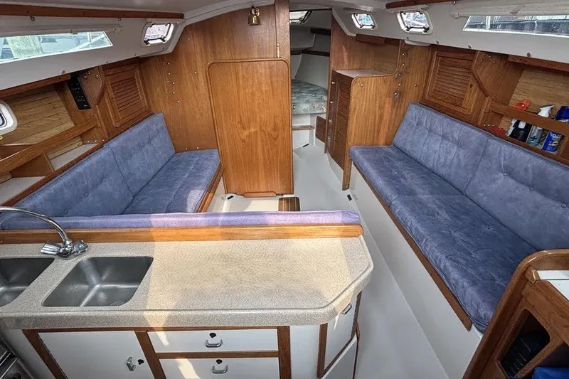 Slide: The Image of Interior of a 1995 Catalina 30 MkIII sailboat with blue seating and wooden cabinetry. - 5