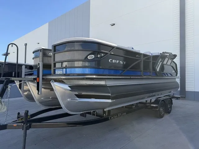 Slide: The Image of A 2023 Crest Caribbean LX 230 SLS CP3 pontoon boat on a trailer in front of a modern building. - 21
