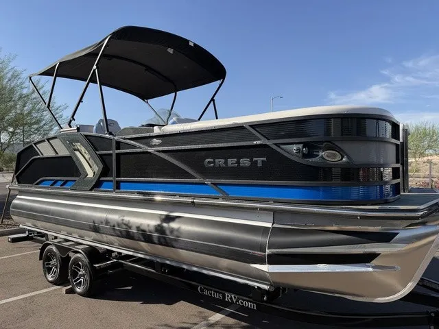 Slide: The Image of A 2023 Crest Caribbean LX 230 SLS CP3 pontoon boat with a black canopy and blue accents. - 3