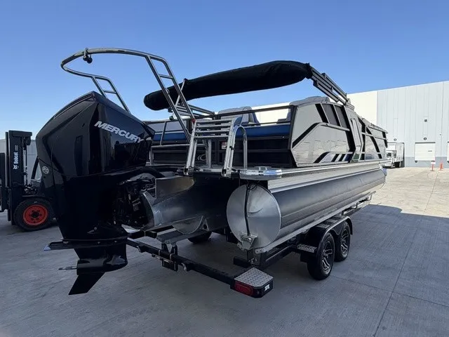 Slide: The Image of A 2023 Crest Caribbean LX 230 SLS CP3 pontoon boat with a Mercury outboard motor, on a trailer. - 2