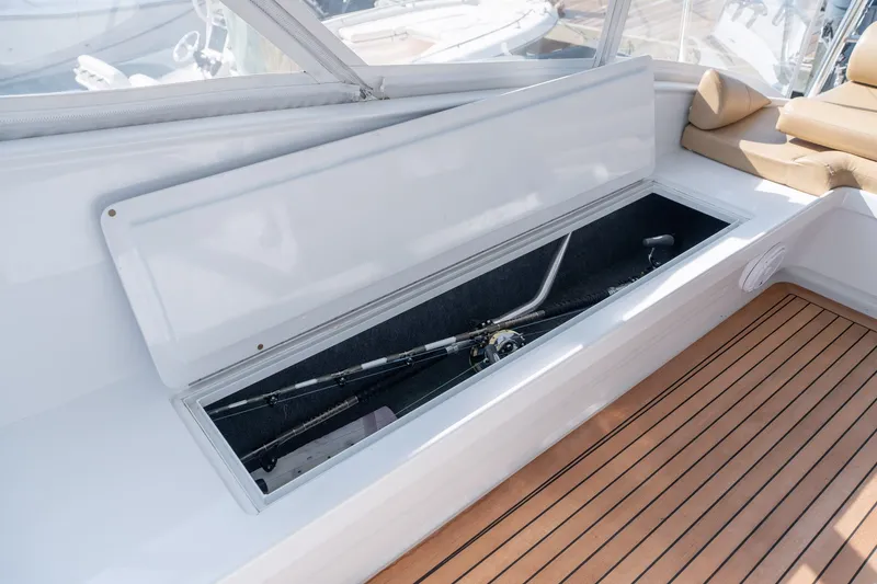 Slide: The Image of Open storage compartment on 2001 Custom Carolina East Bay boat with fishing rods inside. - 34