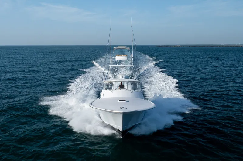 Slide: The Image of Custom Carolina East Bay 2001 yacht cruising swiftly on open ocean waters. - 11