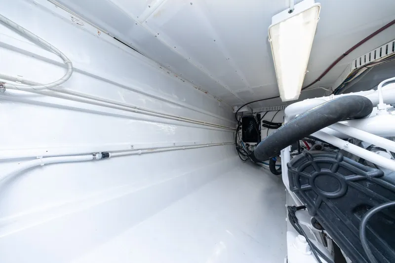 Slide: The Image of Engine room of 2001 Custom Carolina East Bay boat, featuring clean white interior and visible machinery. - 59